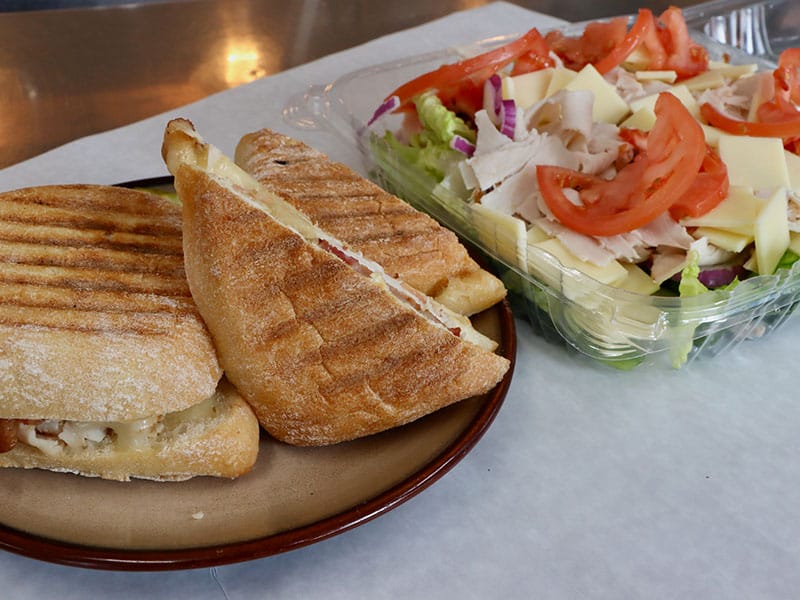 A grilled sandwich with a garden salad